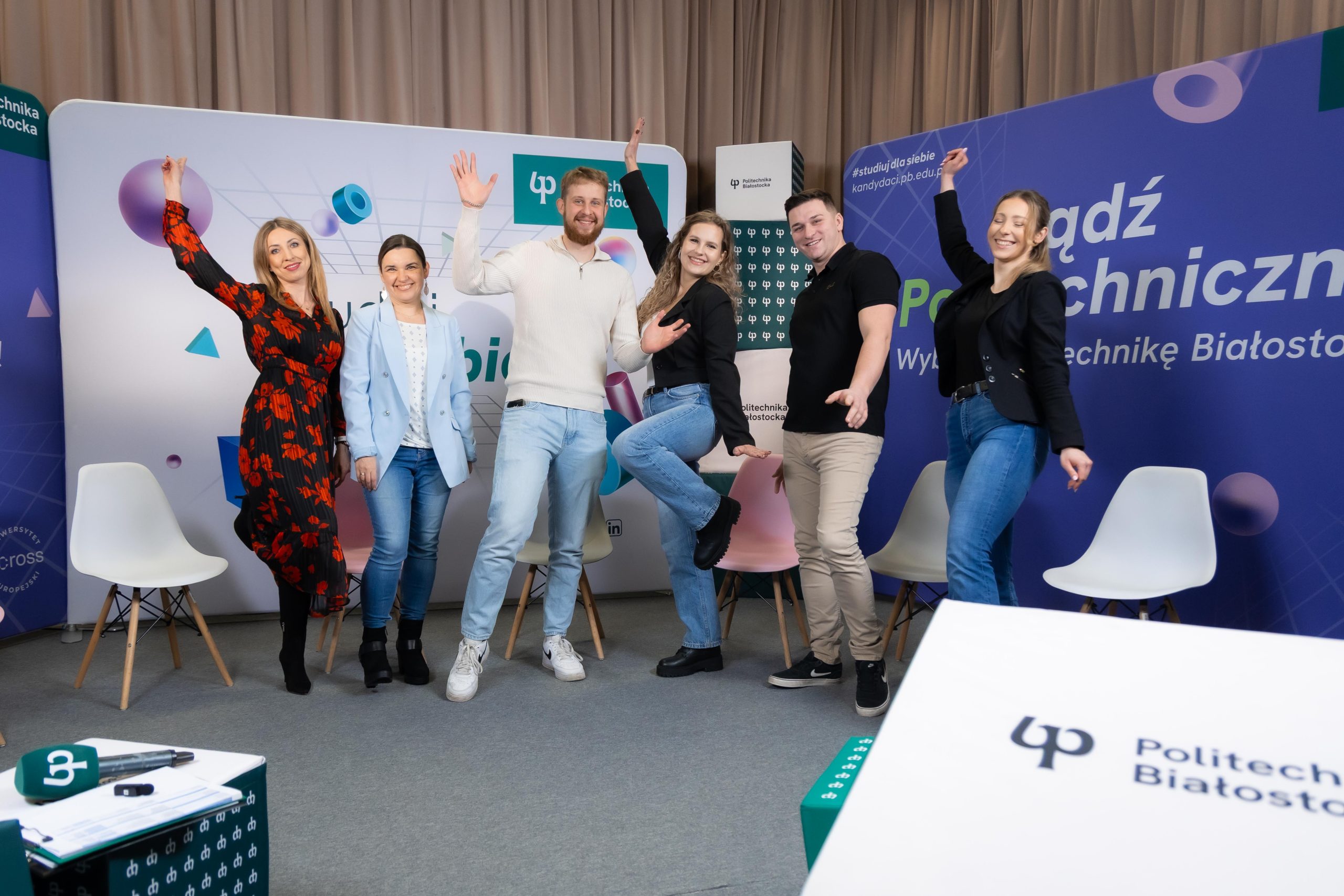 cztery kobiety i dwóch mężczyzn pozuje w radosnych gestach w studiu Platon TV